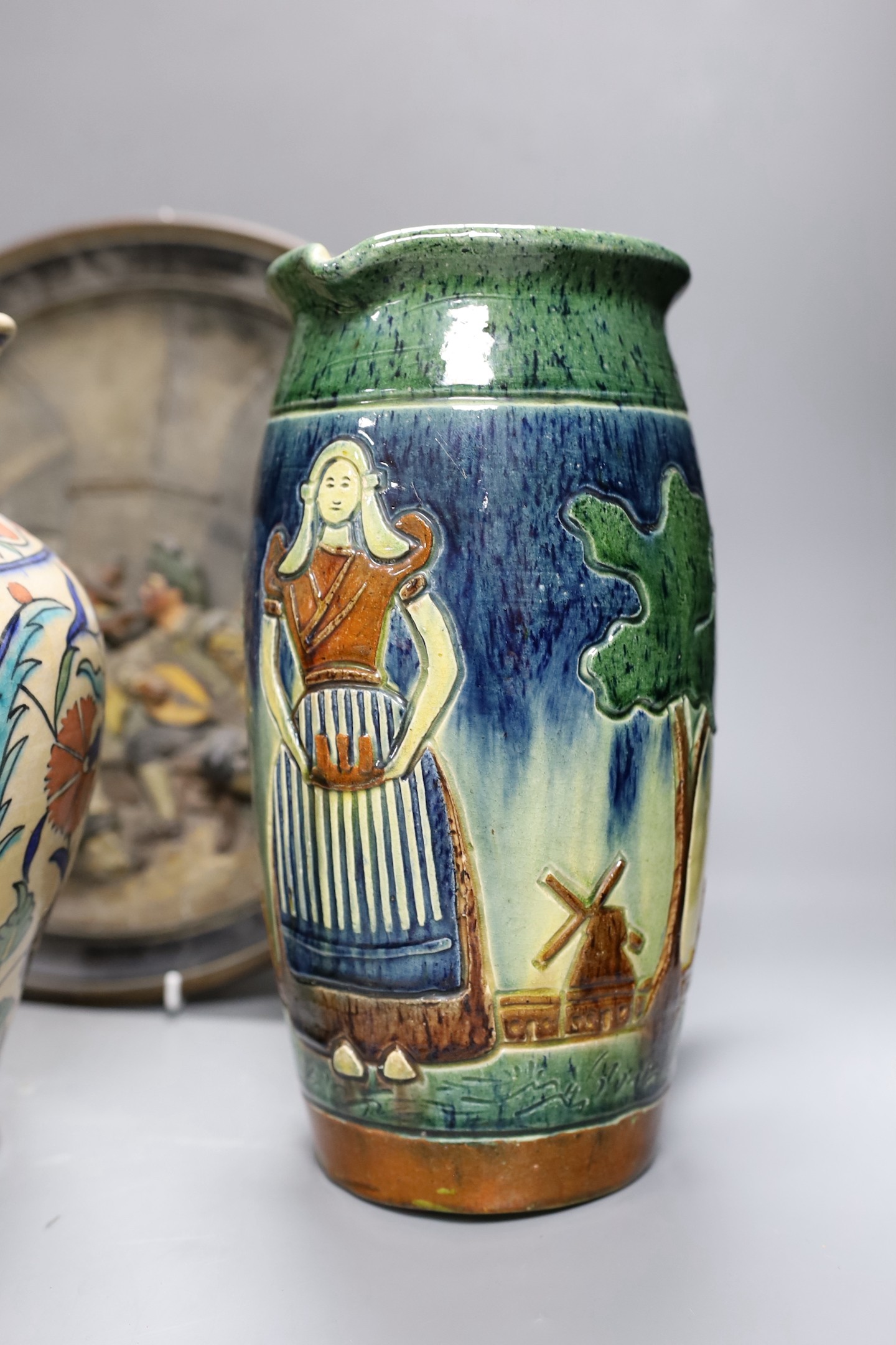 A Dutch jug, a polychrome vase and a Maresch Musterschutz moulded wall plaque, 33 cm diameter